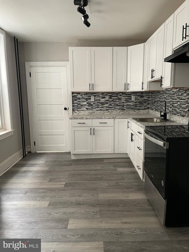 kitchen with stainless steel electric range oven, sink, and white cabinets