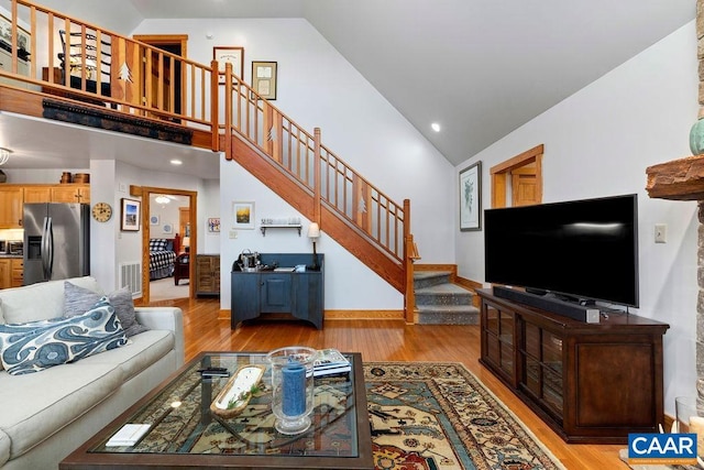 living room featuring light wood-type flooring and high vaulted ceiling