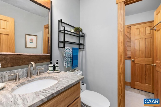 bathroom with tile patterned floors, vanity, and toilet