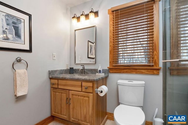 bathroom featuring vanity, toilet, and a shower with shower door