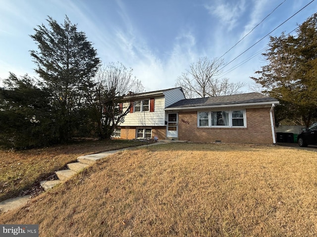 split level home featuring crawl space, brick siding, and a front lawn