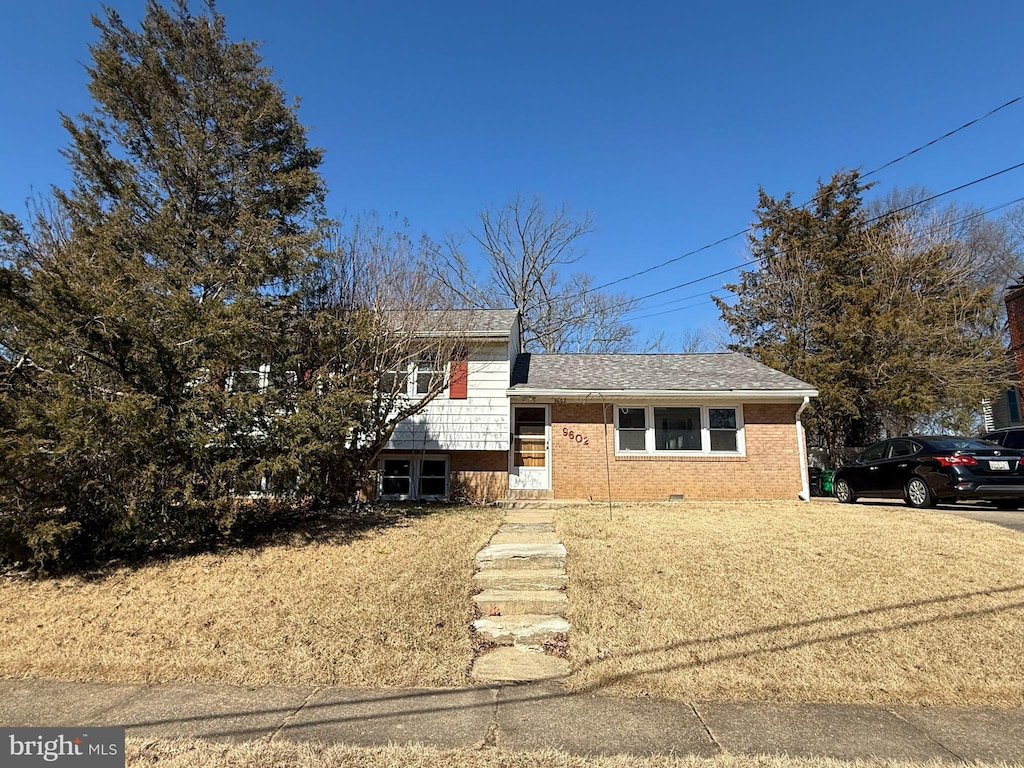 split level home with crawl space, brick siding, and roof with shingles