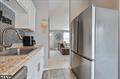 kitchen with stainless steel fridge and white cabinets