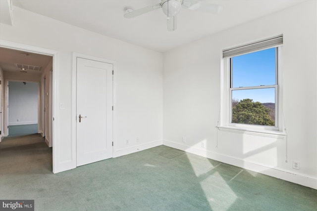 unfurnished bedroom with dark colored carpet and ceiling fan