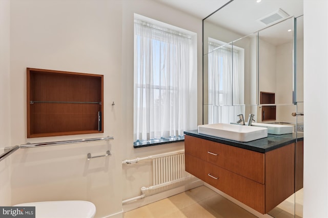 bathroom featuring tile patterned floors, vanity, plenty of natural light, and radiator