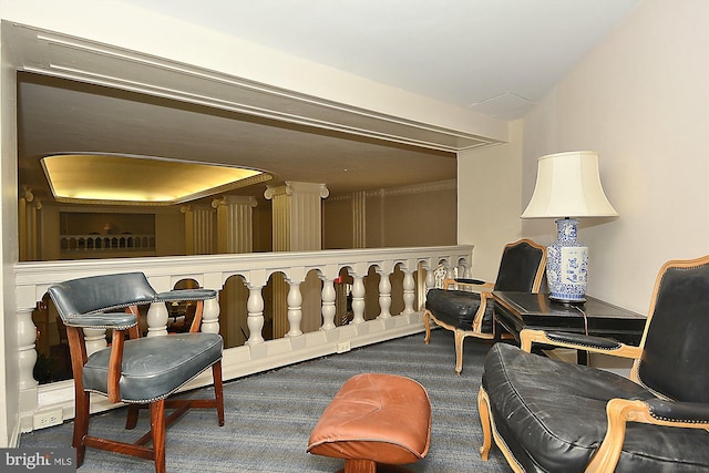 sitting room featuring dark carpet and a tray ceiling