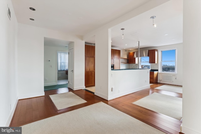 kitchen with radiator, hanging light fixtures, and dark hardwood / wood-style floors