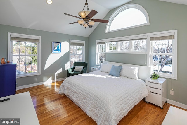 bedroom with multiple windows, ceiling fan, light hardwood / wood-style floors, and vaulted ceiling