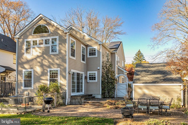 back of property featuring a patio area, cooling unit, and a fire pit