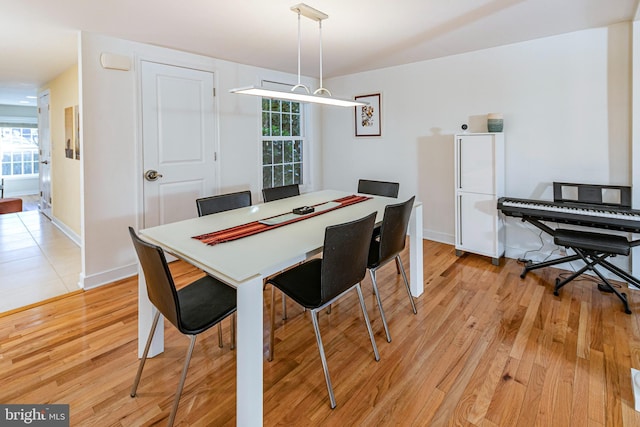 dining area with light hardwood / wood-style flooring and a healthy amount of sunlight