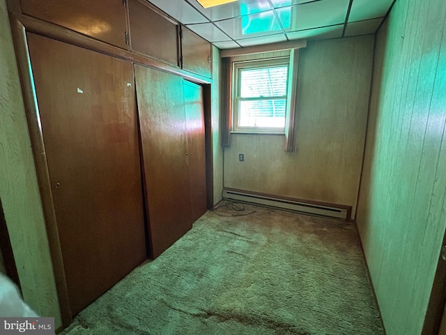 entryway with a paneled ceiling, carpet, and baseboard heating