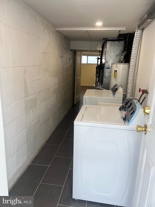 clothes washing area with separate washer and dryer and water heater