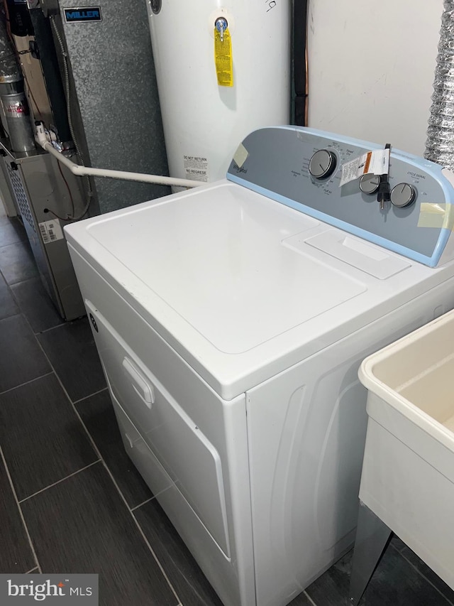 laundry area with gas water heater, sink, and washer / clothes dryer