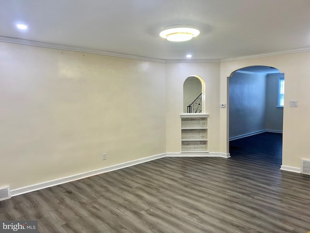 empty room featuring crown molding and dark wood-type flooring