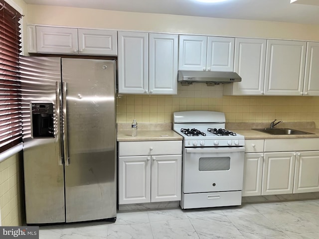 kitchen featuring white cabinets, stainless steel fridge, white gas range oven, and sink