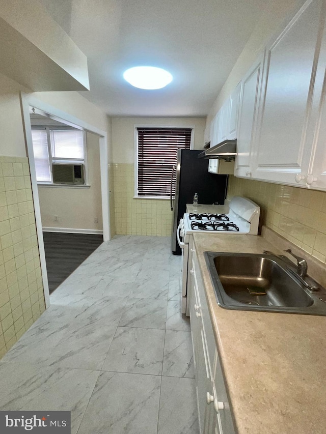 kitchen featuring white cabinets, white gas range oven, and sink