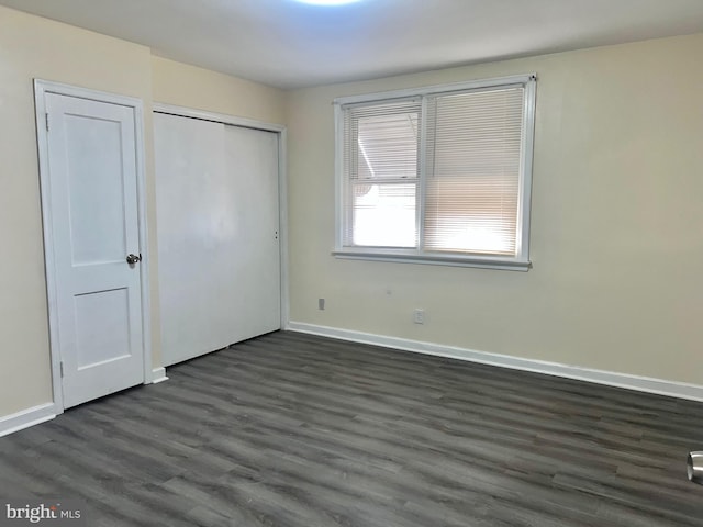 unfurnished bedroom with dark wood-type flooring