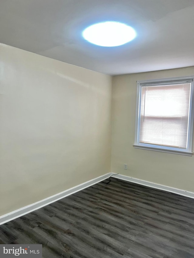 spare room with dark hardwood / wood-style flooring