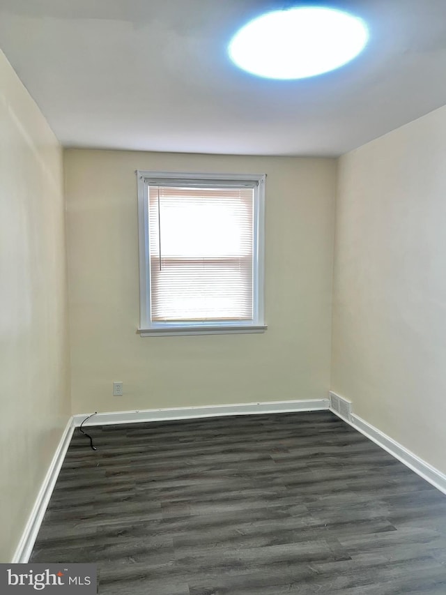 empty room with dark hardwood / wood-style flooring