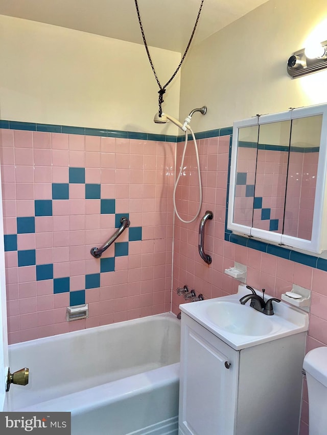 full bathroom featuring tiled shower / bath combo, backsplash, toilet, vanity, and tile walls