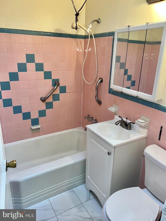 full bathroom with vanity, tiled shower / bath combo, tile walls, and toilet