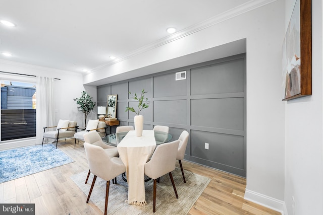 dining area featuring crown molding and light wood-type flooring