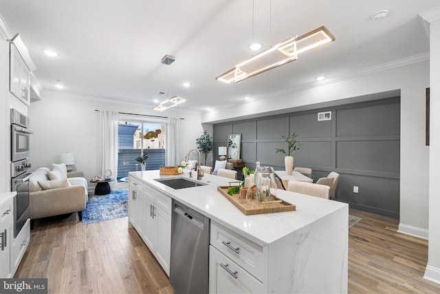 kitchen featuring a center island with sink, dishwasher, white cabinetry, and sink