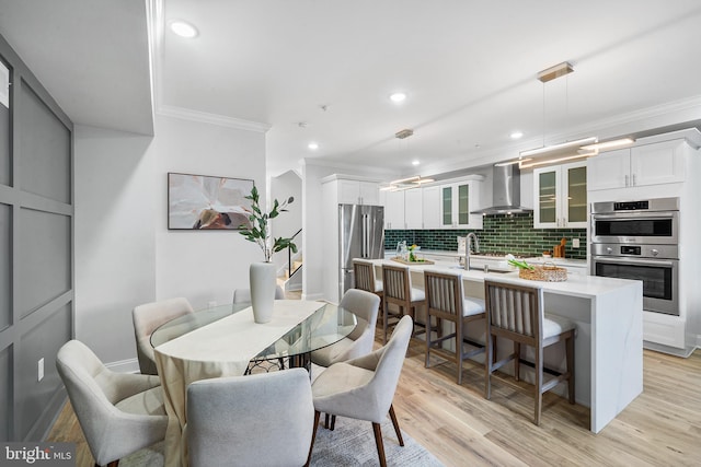 dining room with light hardwood / wood-style floors and crown molding