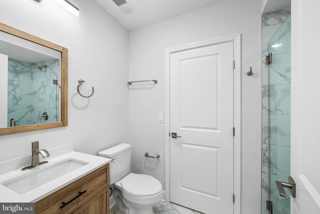 bathroom featuring vanity, an enclosed shower, and toilet