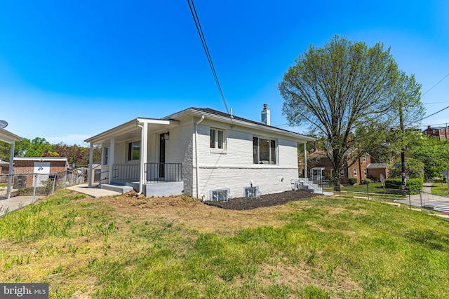 view of side of home with a lawn and a porch