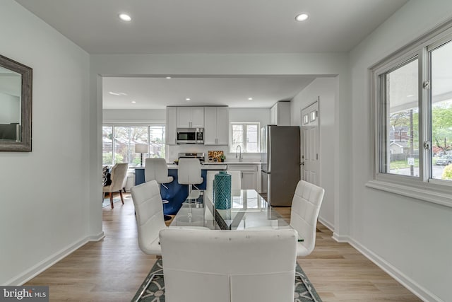 dining room with light hardwood / wood-style floors and sink