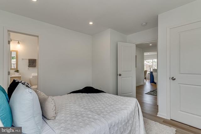 bedroom featuring ensuite bathroom and hardwood / wood-style floors