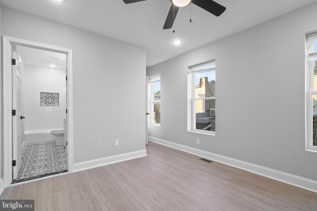 unfurnished bedroom featuring light hardwood / wood-style floors, ceiling fan, and ensuite bathroom