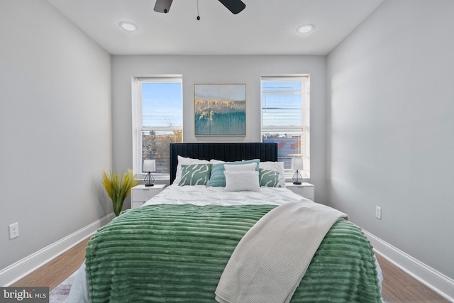 bedroom with hardwood / wood-style flooring, ceiling fan, and multiple windows