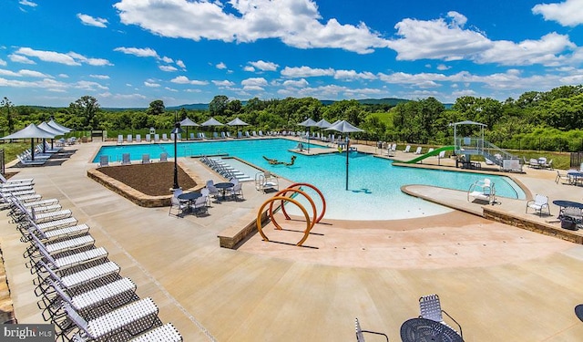 view of pool with a patio and a water slide