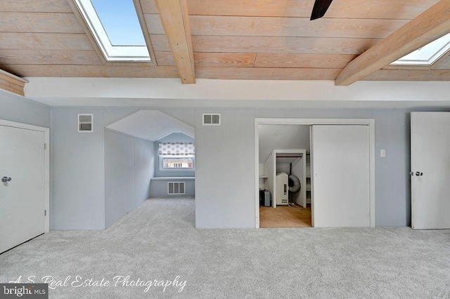 interior space with light carpet, wooden ceiling, and vaulted ceiling with skylight