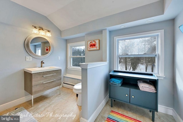 bathroom with a baseboard heating unit, toilet, vaulted ceiling, and vanity