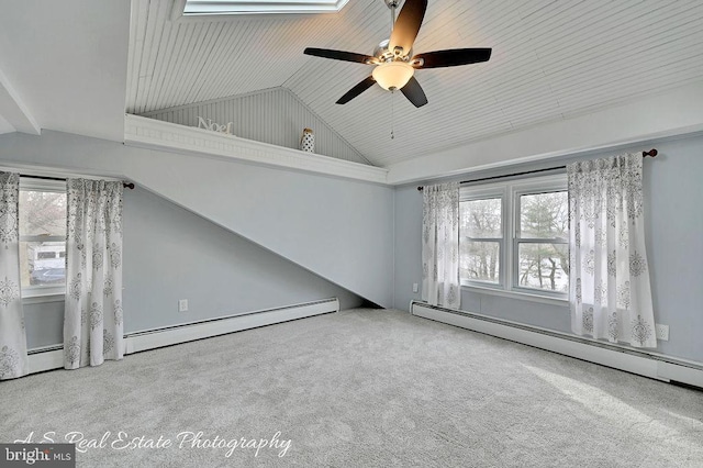 carpeted empty room featuring baseboard heating, a wealth of natural light, and lofted ceiling