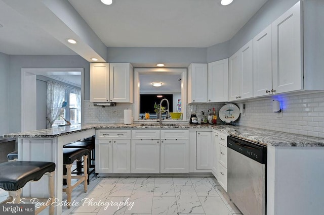 kitchen with white cabinetry, dishwasher, and kitchen peninsula