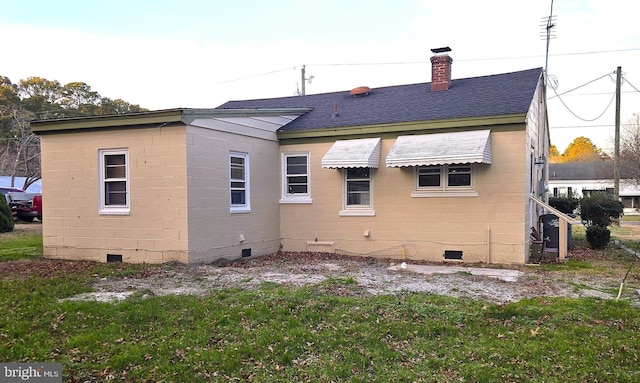 rear view of house featuring a lawn