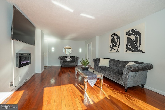 living room featuring wood-type flooring and a textured ceiling