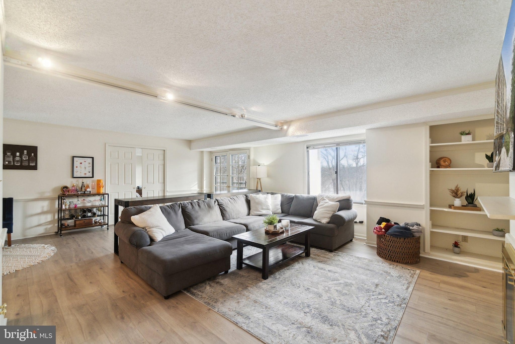 living room featuring light hardwood / wood-style floors and a textured ceiling