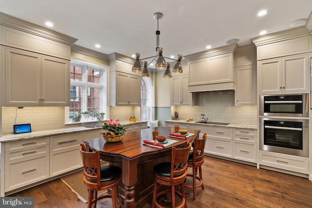 kitchen with light stone counters, a notable chandelier, dark wood-style flooring, backsplash, and decorative light fixtures