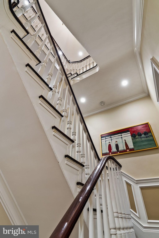 stairway featuring a wainscoted wall, a decorative wall, recessed lighting, and crown molding