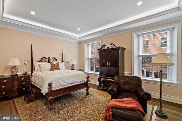 bedroom with ornamental molding, wood finished floors, and baseboards