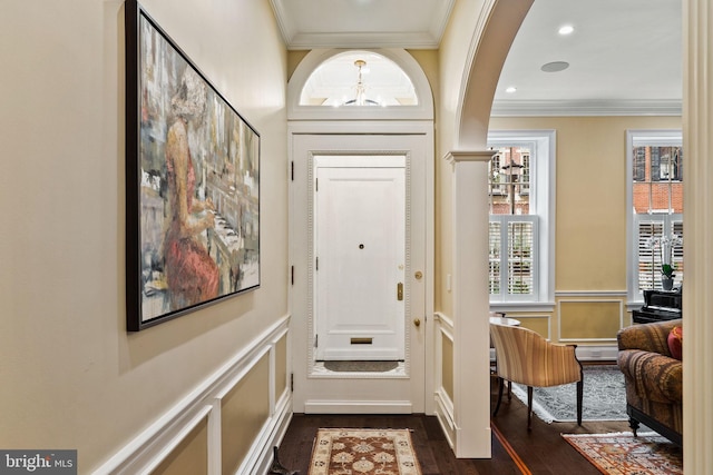 doorway to outside with a wainscoted wall, dark wood-style flooring, crown molding, a decorative wall, and recessed lighting