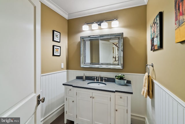 bathroom featuring ornamental molding, wainscoting, and vanity