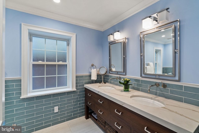 bathroom with crown molding, a sink, and tile walls