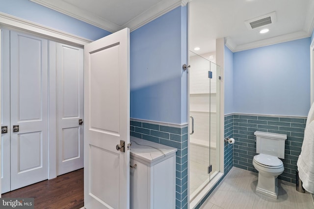 bathroom with toilet, visible vents, tile walls, and ornamental molding