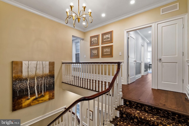 corridor with visible vents, ornamental molding, and an upstairs landing